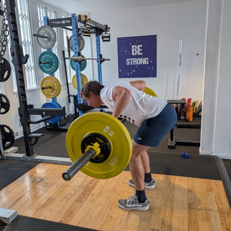 Real World Fitness personal training client learning a Pendlay row in the gym